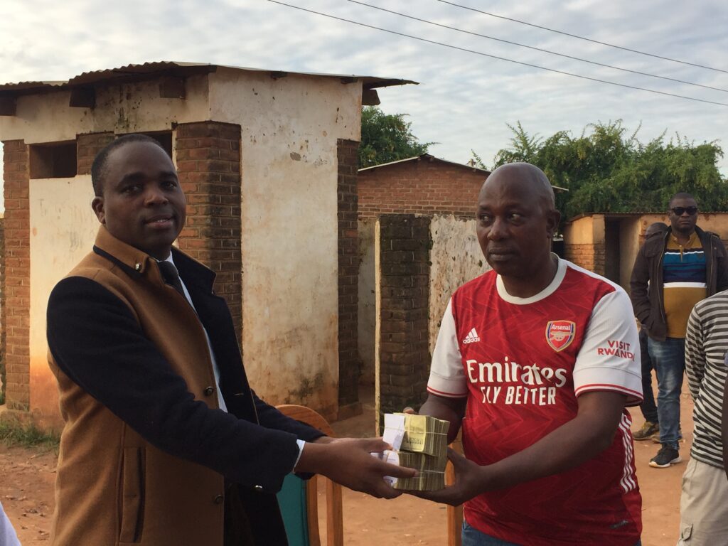 Chisi presenting the donation to Group Village Headman Chilobwe. Pic. Chilungamo Missi. (MANA).